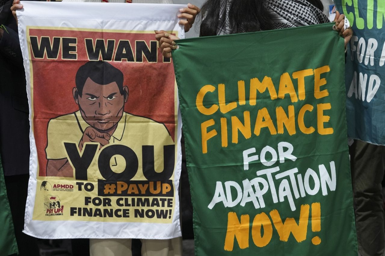 Activists hold banners as part of a demonstration for climate finance.