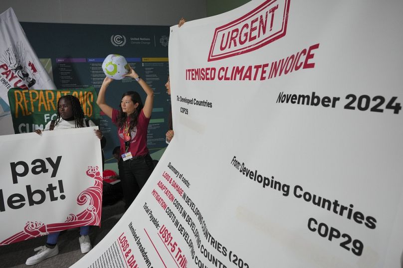 Activists unravel a 10m long itemised invoice for climate damages. 