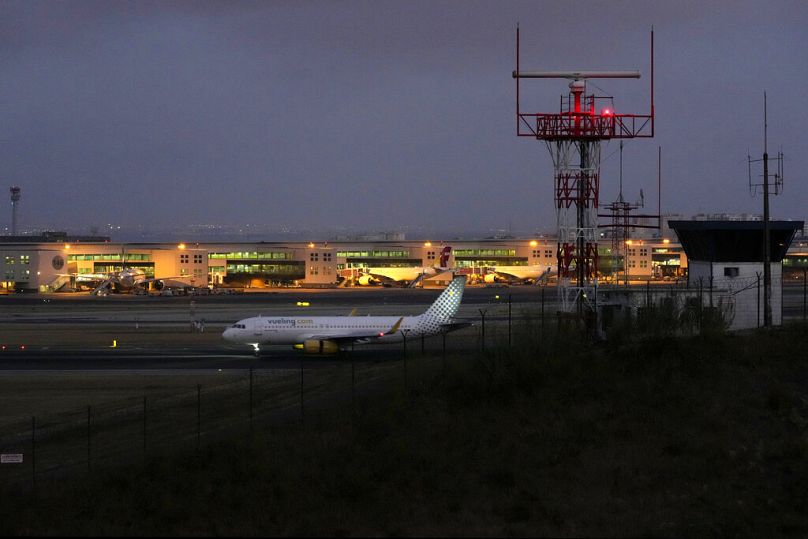 A plane arrives into Lisbon airport at night