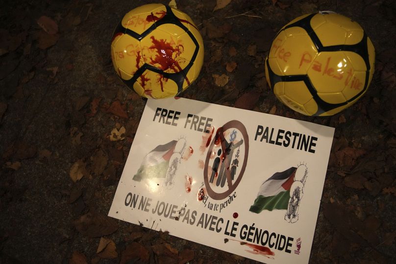 Des ballons de football et une affiche lors du rassemblement de soutien au peuple palestinien avant le match de la Ligue des Nations opposant la France à Is