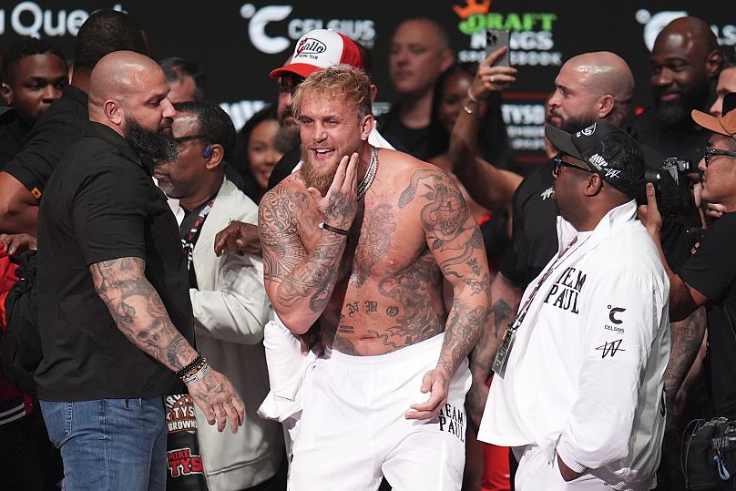 Jake Paul reacts after being slapped by Mike Tyson during a weigh-in ahead of their heavyweight bout. 