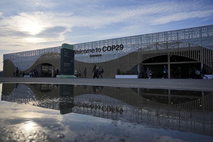 Des personnes à l'extérieur du site du sommet climatique de l'ONU COP29, le samedi 16 novembre 2024, à Bakou, en Azerbaïdjan.