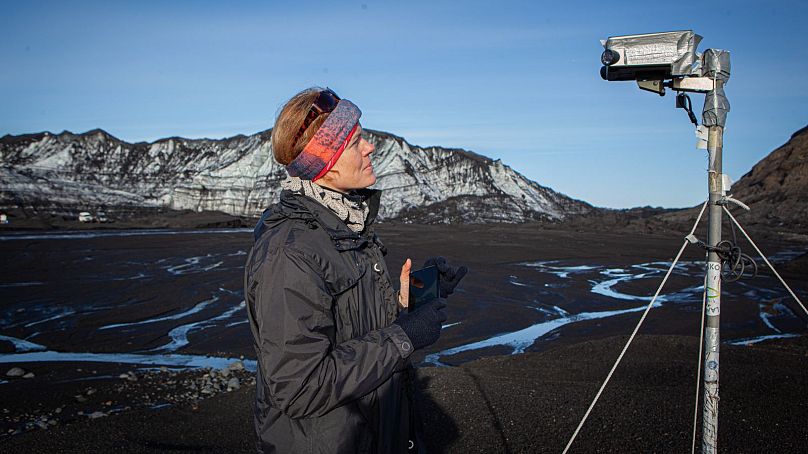 Pavla Dagsson-Waldhauserova examina a sua câmara de 220 graus em frente ao glaciar Myrdalsjokull.