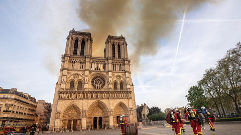 This photo provided Tuesday April 16, 2019 by the Paris Fire Brigade shows fire fighters heading to the burning Notre Dame cathedral, Monday April 15, 2019. 