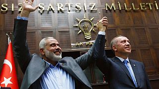 Il premier di Hamas della Striscia di Gaza Ismail Haniyeh, a sinistra, e il suo omologo turco Recep Tayyip Erdogan salutano insieme al Parlamento di Ankara, in Turchia, il 3 gennaio 2012.