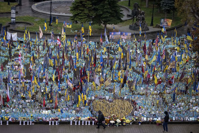 Des gens passent devant le mémorial aux soldats tombés au combat sur la place de l'Indépendance à Kyiv, en Ukraine, le vendredi 15 novembre 2024.