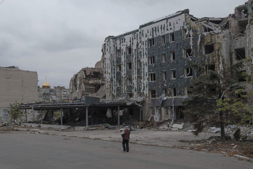 A woman walks in front of Druzhba hotel destroyed by Russian airstrikes in Pokrovsk, November 2024