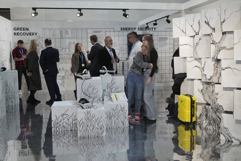 People walk through the Ukraine Pavilion at COP29. 