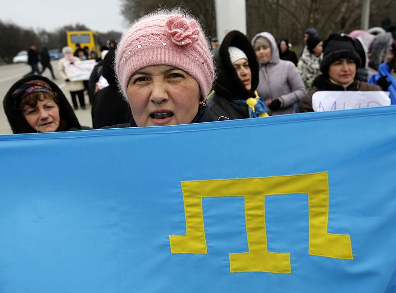 Crimean Tatars shout slogans and hold Tatar flag during the pro Ukraine rally in Simferopol, Crimea, Ukraine, Monday, March 10, 2014.