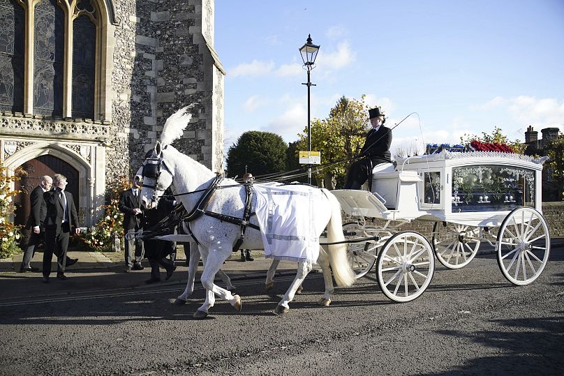 A horse-drawn carriage carrying the coffin of Liam Payne arrives for the funeral service of the One Direction singer at St Mary's Church.