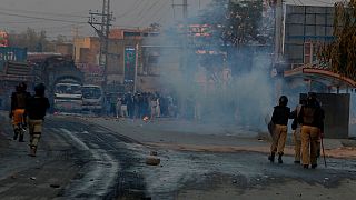 Police officers chase angry protestors in Peshawar, Pakistan, Tuesday, Nov. 19, 2024.