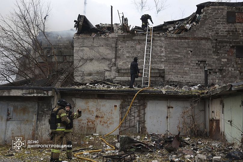 Rescue workers put out a fire of a building which was heavily damaged by a Russian strike on Dnipro, 21 November, 2024 