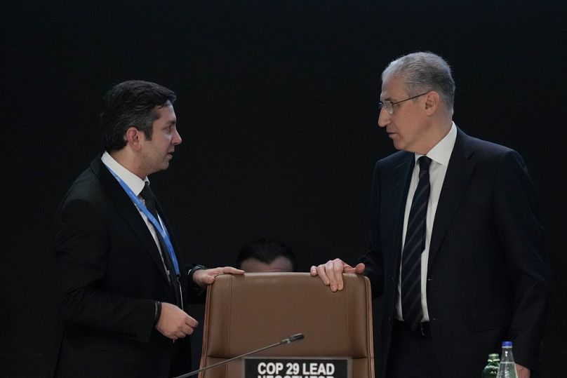 Yalchin Rafiyev, Azerbaijan's COP29 lead negotiator, left, talks to Mukhtar Babayev, COP29 President, ahead of a plenary session.