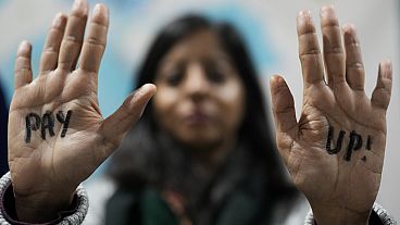 A demonstrator displays hands that read "pay up" during a protest for climate finance at the COP29 U.N. Climate Summit, Saturday, Nov. 23, 2024, in Baku, Azerbaijan.