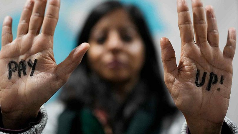 A demonstrator displays hands that reads "pay up" during a protest for climate finance at the COP29 UN Climate Summit, Saturday, Nov. 23, 2024, in Baku, Azerbaijan.