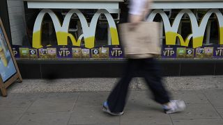 A woman walks by a McDonald's restaurant in London in 2021.