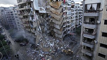 Bulldozer rimuovono le macerie di un edificio distrutto domenica sera da un attacco aereo israeliano a Dahiyeh, sobborgo meridionale di Beirut, Libano, 25.11.2024