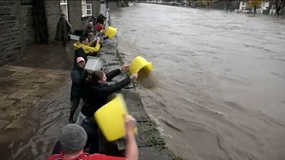 أشخاص يتدافعون لمنع وصول المياه إلى منازلهم. بونتيبريد، المملكة المتحدة بتاريخ 24.11.2024