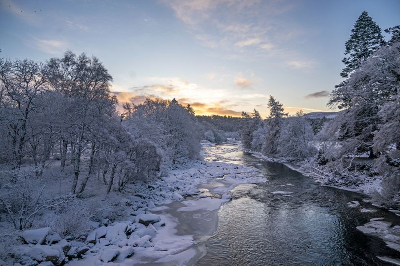 The sun rises over the partially frozen River Dee in Scotland