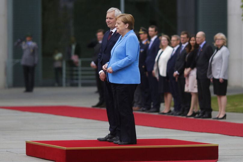 Angela Merkel and Prime Minister of Finland Antti Rinne listen to the national anthems at the chancellery in Berlin