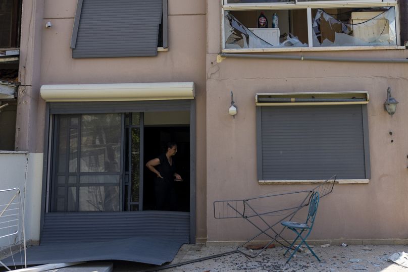 امرأة تقف في منزل متضرر في أعقاب هجوم من لبنان في عكا، شمال إسرائيل، الأحد، 25 أغسطس/آب 2024