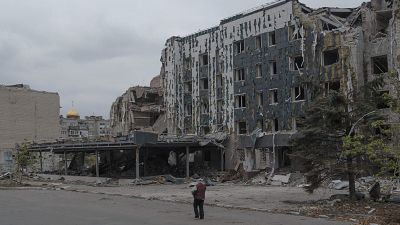 A woman walks in front of Druzhba hotel destroyed by Russian airstrikes in Pokrovsk, Monday, Nov. 11, 2024