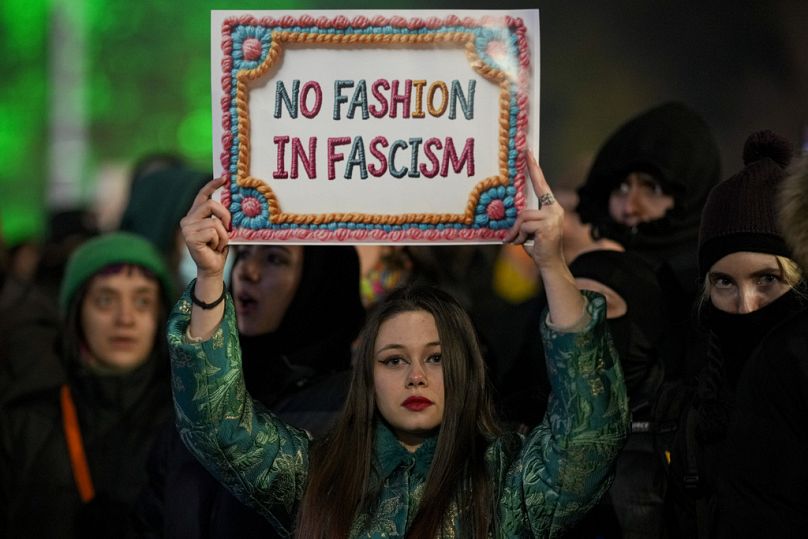 Calin Georgescu'ya karşı düzenlenen protesto sırasında bir kadın "Faşizmde moda yok" yazılı pankart taşıyor.