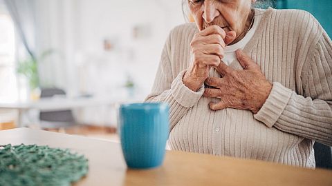 An older woman coughs.