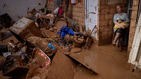 Dolores Merchan, 67, looks down on her mud-splattered belongings from the house where she has lived all her life.