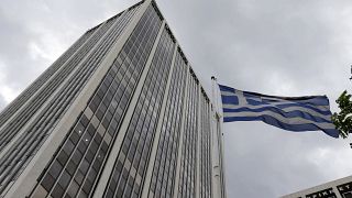 A Greek flag waves outside an office building in Athens, Friday, June 5, 2014.
