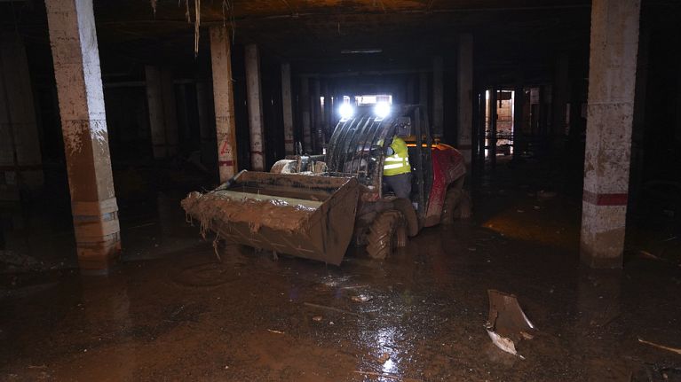 Mud is scooped up after floods in Catarroja that left hundreds dead or missing in the Valencia region in Spain, Tuesday, Nov. 12, 2024.