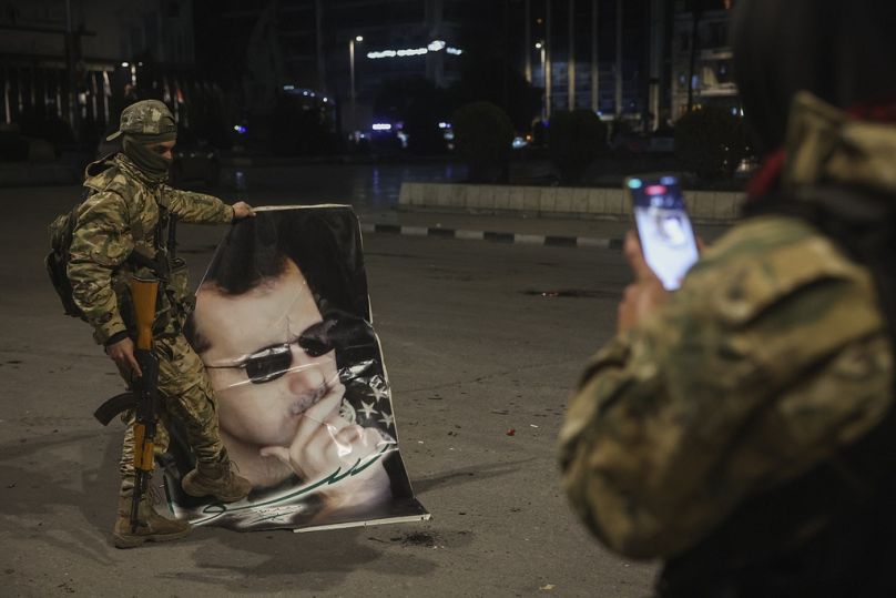 Soldado rebelde fotografa outro a pisar retrato do presidente sírio Bashar al-Assad