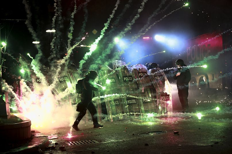 Demonstranten gehen mit Feuerwerkskörpern gegen die Polizei vor dem Parlamentsgebäude in Tiflis vor, 30. November 2024