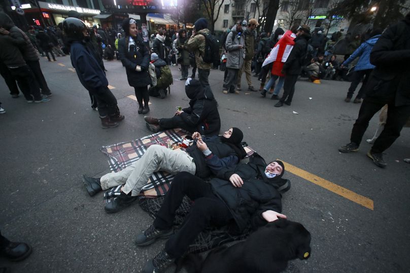 Des manifestants se reposent au milieu des manifestations contre la décision du gouvernement de suspendre les négociations d'adhésion à l'Union européenne, 1er décembre 2024.