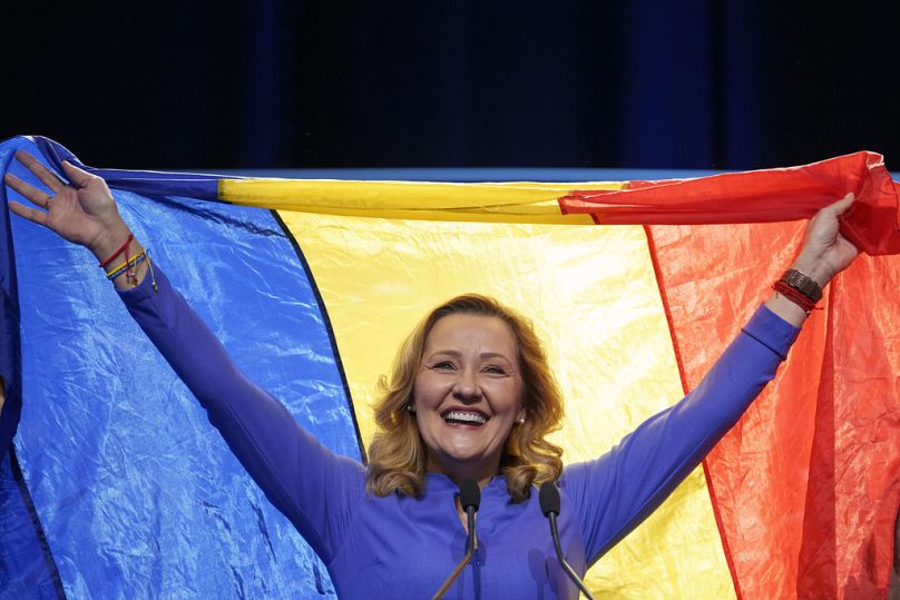 Elena Lasconi, candidata del partido Unión para Salvar Rumanía (USR), sostiene la bandera de Rumanía al final de un mitin con simpatizantes tras pasar a la segunda vuelta.