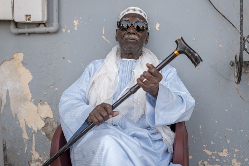 Biram Senghor, cujo pai Mbap foi morto em 1944, posa à entrada da casa do seu irmão Amhet, em Rufisque, Senegall