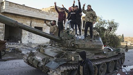 Anhänger der syrischen Opposition stehen auf einem erbeuteten Panzer der syrischen Armee in der Stadt Maarat al-Numan, südwestlich von Aleppo, Syrien, Samstag, 30. November 2024. 