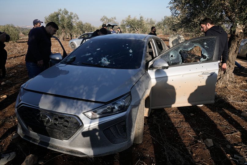 أشخاص يتفقدون سيارة مليئة بثقوب الرصاص بعد توغل الجيش الإسرائيلي في قرية صير بالقرب من جنين في الضفة الغربية المحتلة يوم الأحد، 1 ديسمبر 2024