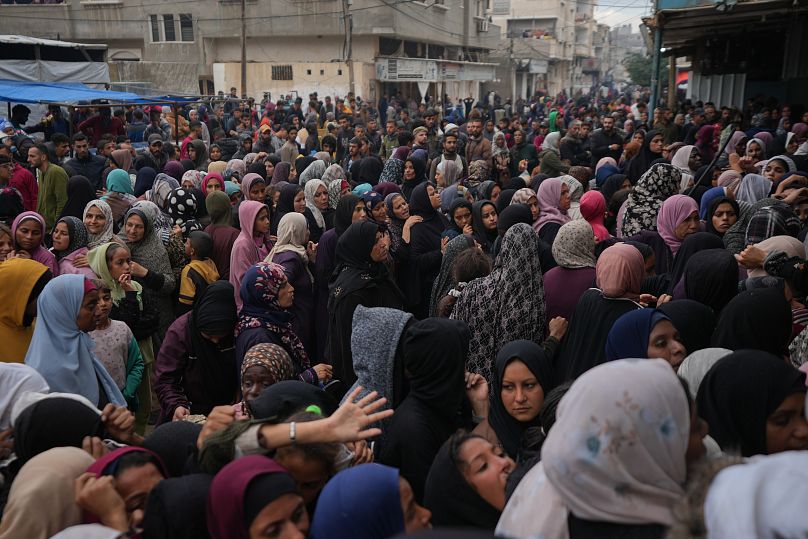 فلسطينيون يتجمعون للحصول على الطعام في مركز توزيع في دير البلح، قطاع غزة، الجمعة 29 نوفمبر/تشرين الثاني 2024
