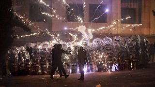 Dimostranti usano petardi contro la polizia durante una manifestazione a Tbilisi, 2 dicembre 2024