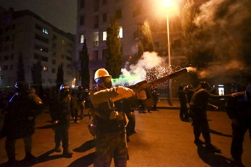 Демонстрант использует петарды против полиции в ходе протестов в Тбилиси, 2 декабря 2024 г.