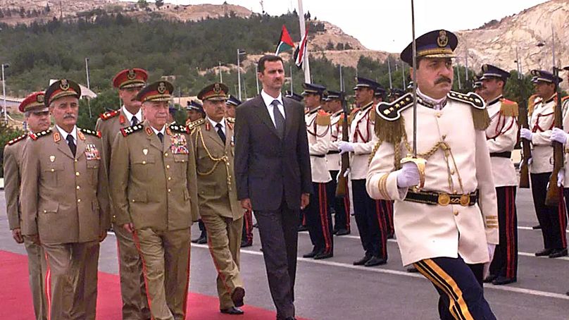 Aszad elnök egy katonai parádén a vezérkar körében, 2018