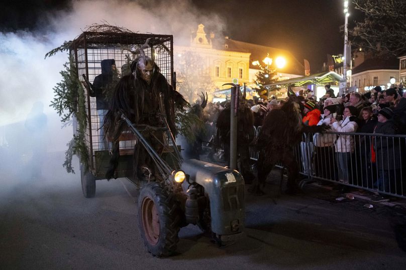 Ein Teilnehmer in einem traditionellen Krampuskostüm fährt einen Traktor während seines Auftritts beim Krampuslauf in Hollabrunn, Österreich, Samstag, 30. November 2024.