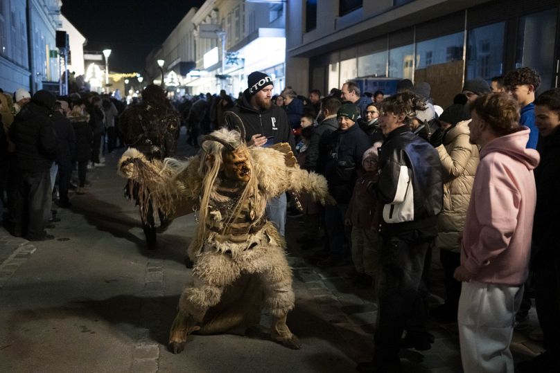 Ein Krampus schlägt einen Jungen während seines Auftritts beim Krampuslauf in Hollabrunn, Österreich, Samstag, 30. November 2024.