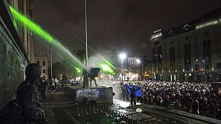 Dimostranti in cima a una tomba sotto l'acqua corrente di un cannone ad acqua si radunano davanti al Parlamento di Tbilisi, in Georgia, lunedì 2 dicembre 2024.