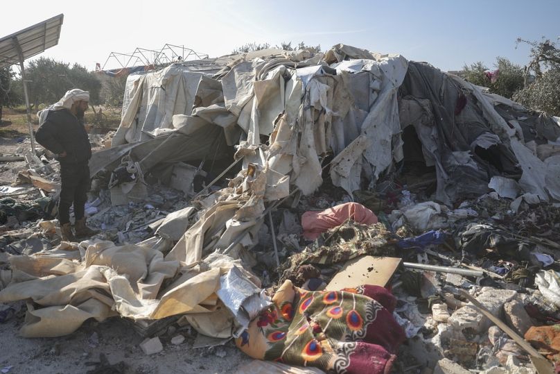 Un uomo osserva un campo per sfollati distrutto durante un attacco aereo vicino al villaggio di Harbnush, a nord di Idlib, Siria, 2 dicembre 2024