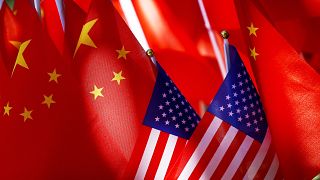 US flags are displayed with Chinese flags on top of a trishaw on September 16, 2018, in Beijing.