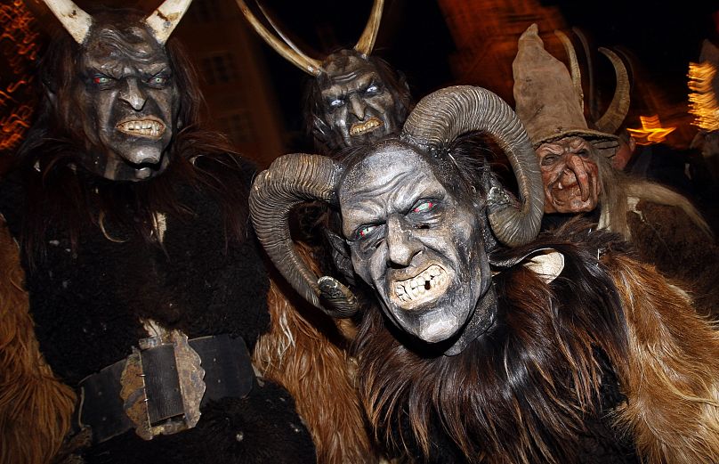 Szőrmejelmezbe öltözött figurák ijesztgetik a Krampuszfutás résztvevőit a müncheni Marienplatzon 2008. december 7-én