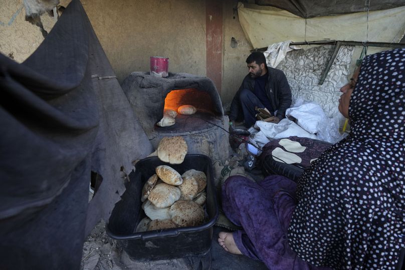 امرأة فلسطينية تخبز في فرن طيني وسط نقص حاد في الغذاء بدير البلح، قطاع غزة، الاثنين 2 ديسمبر 2024.