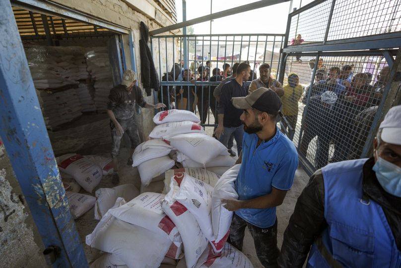  توزيع الدقيق على الفلسطينيين في مركز للأونروا في مخيم النصيرات للاجئين، قطاع غزة، الثلاثاء 3 ديسمبر، 2024. 